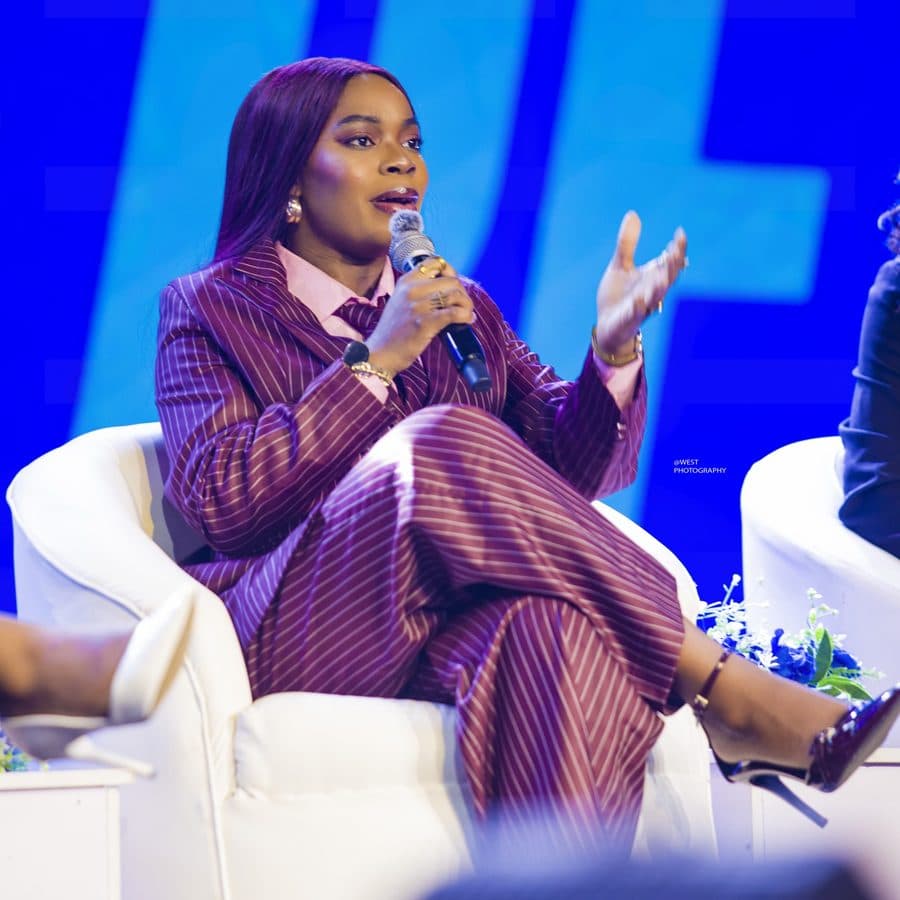 Achie gesturing as she answers a question on a conference panel